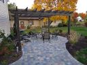 Pergola with outdoor ceiling fan and sconce lights on each post